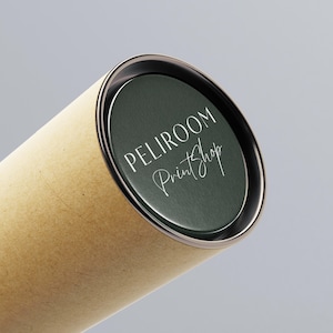 K&ouml;nnte beinhalten: Eine zylindrische Pappr&ouml;hre mit einem dunkelgr&uuml;nen Deckel. Der Deckel hat einen silbernen Rand und die Worte "PELIROOM PrintShop" in wei&szlig;er Schrift. Die R&ouml;hre ist hellbraun.