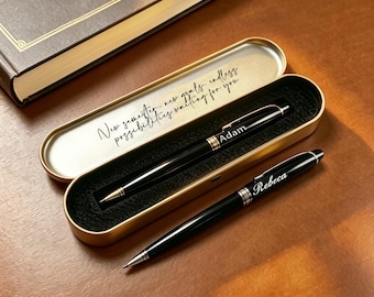 Puede incluir: Dos bolígrafos negros con detalles y clips plateados. Un bolígrafo está grabado con el nombre Adam y descansa dentro de un estuche de metal dorado. El otro bolígrafo está grabado con el nombre Rebeca. La tapa del estuche tiene el texto New semester, new goals, endless possibilities waiting for you.