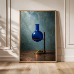 May include: A vibrant cobalt blue glass round-bottom boiling flask is securely held within a brass-toned metal laboratory stand. The flask features a long, narrow neck and a spherical body, resting on a circular base with a vertical support rod.