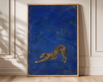 Puede incluir: Una impresión de arte mural rectangular en un marco de madera clara que muestra un galgo atigrado en posición de estiramiento sobre un fondo azul profundo y texturizado. El perro está situado en la parte inferior central, con las patas delanteras extendidas.