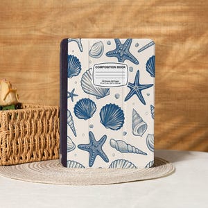 Puede incluir: Cuaderno de composición con una cubierta color crema con un patrón de conchas marinas y estrellas de mar azules. El cuaderno tiene un lomo azul oscuro y el texto "COMPOSITION BOOK" es visible. Mide 20.3 x 17.8 cm y contiene 200 páginas.
