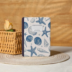 May include: A composition book with a cream-colored cover featuring a pattern of blue seashells and starfish. The words "COMPOSITION BOOK" are printed on the cover, along with a blank space for a name. The book measures 9.5 in x 7.5 in x 0.7 in.