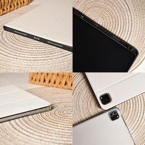 May include: A light beige tablet case with a black border. The case is shown from multiple angles, revealing the details of the design and the tablet's features. The case is shown on a beige woven surface.