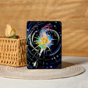 May include: A rectangular tablet case featuring a vibrant illustration of a celestial figure. The artwork showcases a woman with flowing, multicolored hair and a burst of colorful energy against a dark blue background. The design includes swirling lines and dots.