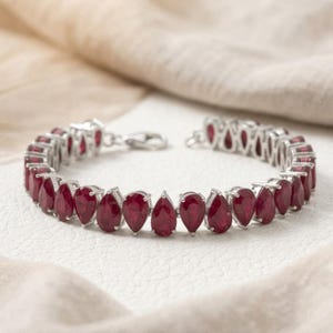 Armband van sterling zilver met natuurlijke peervormige robijn – geboortesteen van juli, een opvallend sieraad.