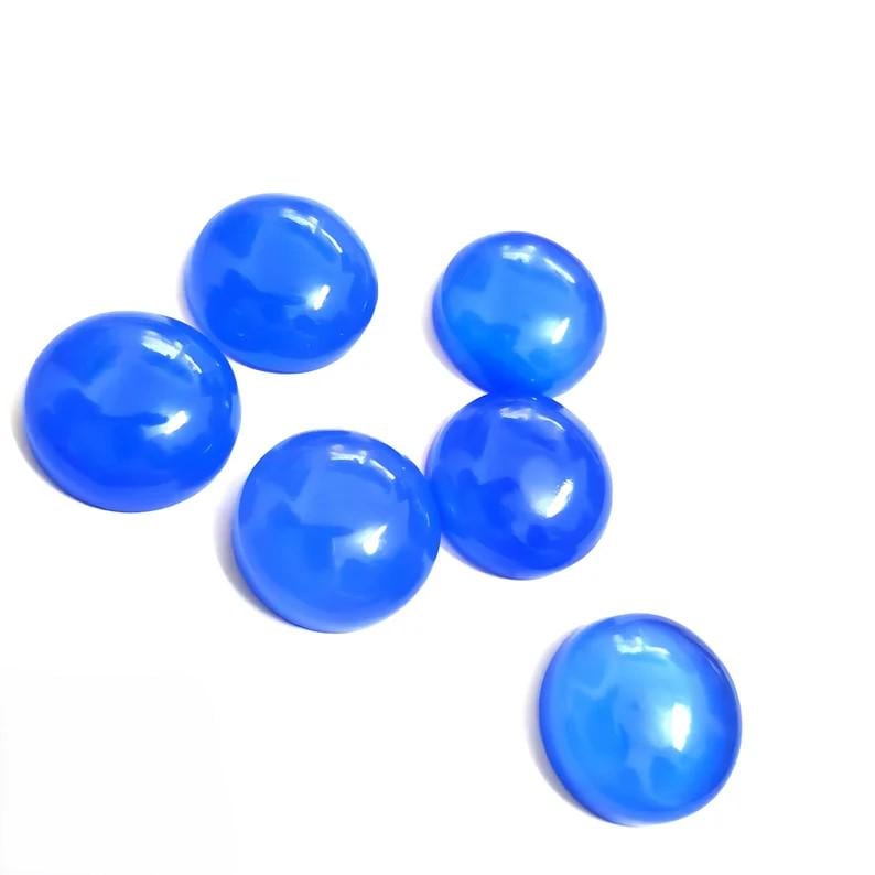 Puede incluir: Seis cabujones redondos y brillantes, de color azul brillante, est&aacute;n dispuestos sobre un fondo blanco. Los cabujones tienen una superficie lisa y pulida y una ligera forma de c&uacute;pula, que refleja la luz.