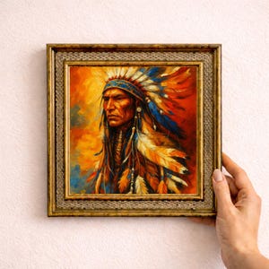 Puede incluir: Pintura enmarcada de un nativo americano con un tocado de plumas. La obra de arte presenta una paleta de colores cálidos de naranja, rojo y amarillo, con acentos azules y blancos. El marco es dorado.