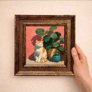 Puede incluir: Un cuadro cuadrado enmarcado que muestra un gato naranja y blanco sentado frente a una pared de ladrillos rosas, junto a una planta grande en una maceta verde y una maceta más pequeña azul. El marco es dorado, ornamentado y texturizado.