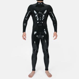 以下が含まれることがあります： ハイネックの襟、長袖、フルレングスの脚部を備えた、全身を覆う黒いラテックス製のキャットスーツ。素材は光沢のある反射仕上げで、体のラインに沿ってフィットし、前面には中央に縦の縫い目が施されています。