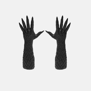 以下が含まれることがあります： 黒色の、ドラゴンの爪の形をしたテクスチャ加工された手袋のペア。手袋は長く尖った指先と、表面全体を覆う鱗のような模様が特徴です。手袋は無地の白い背景に表示されています。