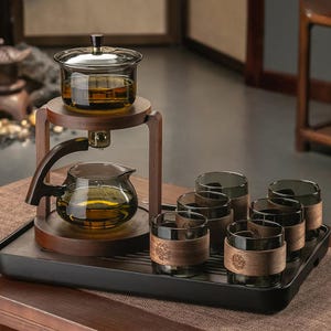 以下が含まれることがあります： 木製のスタンドとトレイが付いたティーセット。 セットには、ガラスのティーポット、醸造容器、木製のスリーブが付いた6つのグラスが含まれています。 ティーセットは、お茶を淹れて提供するように設計されています。