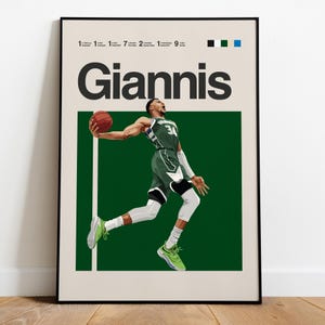 Peut inclure: Impression d'art encadrée représentant un joueur de basket-ball en uniforme vert et blanc, en plein saut, tenant un ballon. Le mot "Giannis" est affiché au-dessus du joueur. Le fond est un rectangle vert foncé avec des lignes blanches.