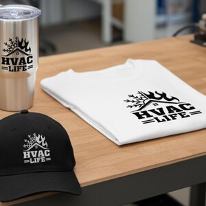 May include: A stainless steel tumbler, a white t-shirt, and a black baseball cap, all with the text "HVAC LIFE" in a black graphic. The tumbler has a lid. The t-shirt is folded. The cap is on a wooden surface.