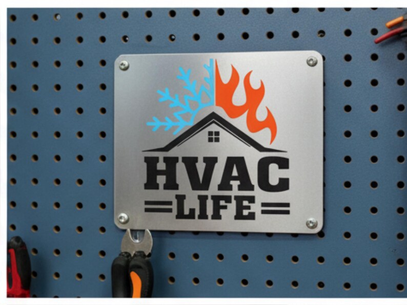 May include: A silver metal sign with the words "HVAC LIFE" in bold black letters. The sign features a graphic of a house with a flame and snowflake design. The sign is mounted on a blue pegboard with tools.