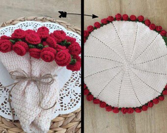 May include: A crochet bouquet of red roses tied with twine, presented on a white doily. Next to it is a round, cream-coloured crochet placemat, edged with red roses and green leaves, ideal for home decor.