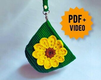 May include: A green crocheted pouch featuring a yellow sunflower design. The pouch has a green strap and a silver clasp. The image includes the text "PDF + VIDEO" in a yellow starburst.