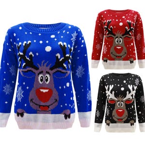 May include: Three Christmas jumpers in blue, red, and black. Each jumper features a reindeer face with a red nose and white antlers. White snowflakes and a white bottom hem complete the design. The jumpers are long-sleeved.