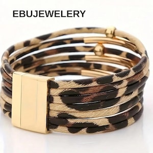 May include: A multi-strand bracelet with a leopard print pattern. The bracelet features a gold-colored magnetic clasp and gold-colored metal accents. The text "EBUJEWELERY" is visible at the top of the image.