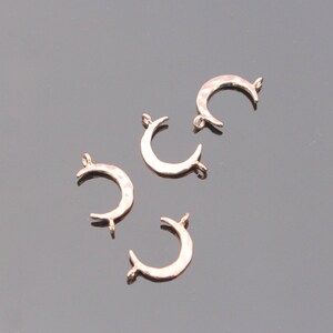 May include: Five gold-toned metal crescent moon charms with a hammered texture. Each charm has a jump ring for attaching to jewelry.