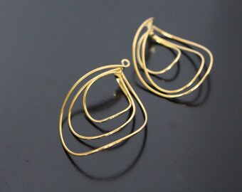 May include: A pair of gold-toned earrings with a teardrop shape and a layered design.