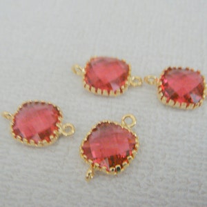 May include: Four gold-toned connectors with red faceted glass stones. Each connector has two loops for attaching to jewelry.