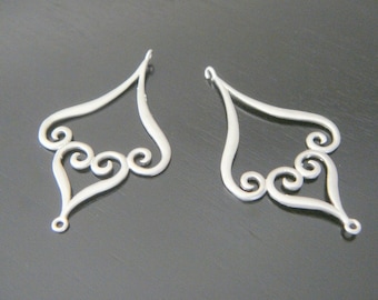 May include: Two silver filigree earring findings with a heart shape and a swirl design.