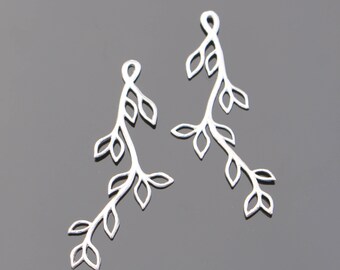 May include: Two silver metal charms shaped like branches with leaves. The charms are delicate and intricate, perfect for adding a touch of nature to jewelry.