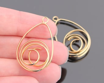 May include: Two gold-tone metal pendant charms with a spiral design. The charms are shaped like teardrops and have a loop at the top for attaching to a necklace or bracelet.