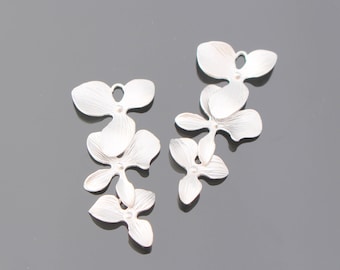 May include: Silver orchid flower charms, each with a delicate, textured finish. The charms are arranged in a cascading pattern, creating a graceful and elegant design.