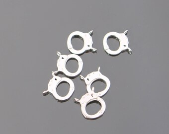 Könnte beinhalten: Sechs silberfarbene Metallverschlüsse, jeder mit einer runden Öffnung und einem Scharnierverschluss. Diese Verschlüsse werden häufig für die Schmuckherstellung und das Basteln verwendet.