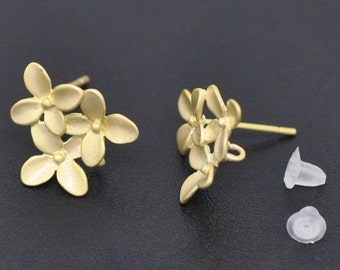 May include: A pair of gold-tone flower stud earrings with a cluster of five flowers on each earring. The earrings have a post back and come with a pair of clear silicone earring backs.