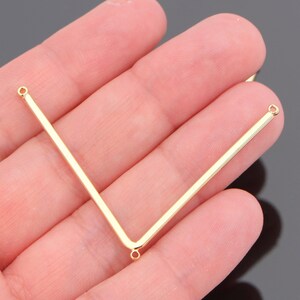 May include: Gold-toned metal V-shaped connector with two jump rings at each end.