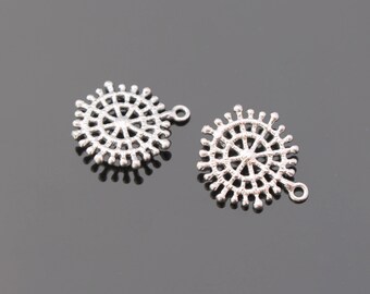 Könnte beinhalten: Zwei silberne Metall-Anhänger in Form eines kreisförmigen Mandalas mit einer Schlaufe an der Seite.