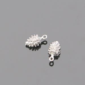May include: Two silver pine cone charms with a loop for attaching to jewelry or other crafts.