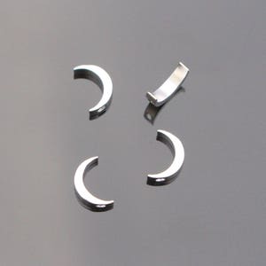 May include: Four silver metal half-circle bead caps with a hole at the top.