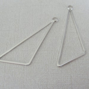 May include: Two silver triangle earring blanks with jump rings.