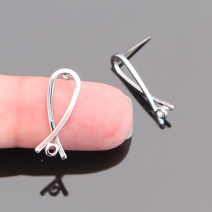 May include: Two silver-toned jewelry findings with a loop on one end and a small loop on the other end. The findings are designed to be used as a connector for jewelry making.