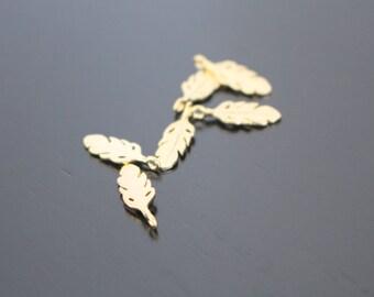 May include: Five gold-colored metal feather charms, each with a loop for attaching to a necklace or bracelet.