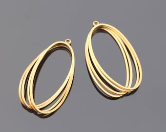 May include: A pair of gold-toned metal earrings with a multi-layered oval design. Each earring has four overlapping ovals.