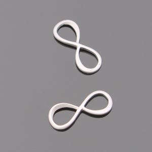 May include: Two silver infinity symbol charms. The charms are smooth and have a shiny finish.