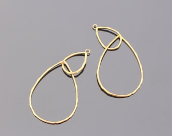 May include: Two gold-toned teardrop-shaped earring blanks with a smaller teardrop shape inside the larger one. The earring blanks are made of metal and have a smooth, polished finish.