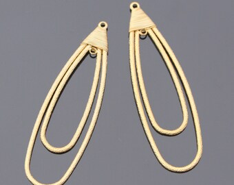 May include: Two gold-colored, textured metal earring pendants. Each pendant has a teardrop shape with two nested loops and a triangular top with a small loop for hanging. The earrings are displayed on a dark gray surface.