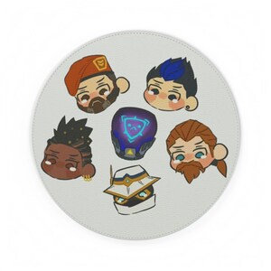 May include: A round, light gray mousepad featuring cartoon illustrations of six characters with various hairstyles and facial hair. The characters are in a circular arrangement, with a purple helmet in the center.