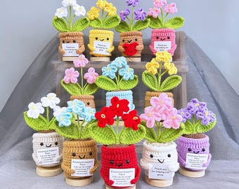 May include: A collection of crochet flower pots in various colors, including white, yellow, pink, blue, red, and purple. Each pot has a smiling face and a small sign. The base is included. The size is 5.51" x 2.36".
