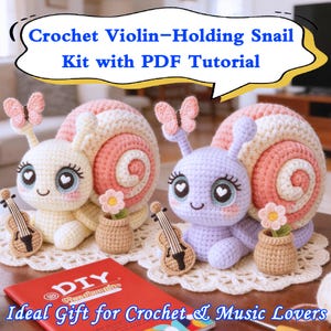 May include: Two crochet snail kits, one cream and one lavender, each holding a miniature violin. The snails have pink and cream shells, butterfly antennae, and are sitting on a white doily. The text reads "Crochet Violin-Holding Snail Kit with PDF Tutorial."
