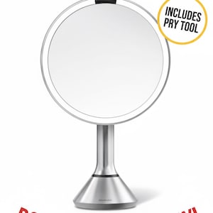 Puede incluir: Un espejo de tocador redondo plateado con una luz LED brillante, montado sobre una base. Se muestra el texto "BATTERY REPAIR GUIDE" y "DON'T THROW IT AWAY!". Incluye una herramienta de palanca.