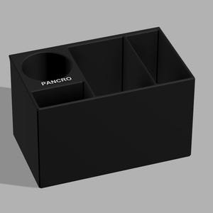 May include: A black desk tidy with several compartments. It includes a round cup holder, a small square section, and two angled dividers. The word "PANCRO" is printed in white on the front. This organiser is designed to hold pens, pencils, and other office supplies.