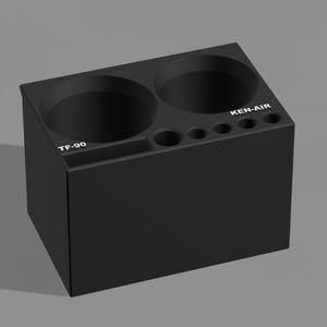 May include: A black, rectangular organizer with two large circular openings and several smaller holes. The text "TF-90" is on the front, and "KEN-AIR" is on the side. The organizer is designed to hold various items.