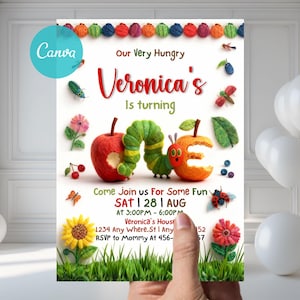 Könnte beinhalten: Eine farbenfrohe Geburtstagseinladung mit dem Text "Veronica's is turning ONE." Das Design zeigt eine grüne Raupe, einen roten Apfel und einen orangefarbenen Apfel. Die Einladung enthält Veranstaltungsdetails und wird von einer Hand gehalten.