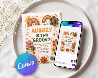 May include: A printed invitation card featuring clay-style rainbows and flowers with the text AUBREY IS TWO GROOVY, displayed next to a smartphone showing the same design in the Canva app interface on a white plate.